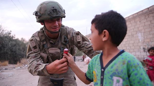 الجندي التركي يرسم البسمة على وجوه أطفال 'تل حلف' السورية