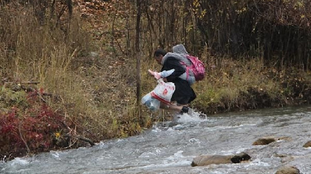 Çocuklarını sırtında taşıyıp servise yetiştirmeye çalışıyor: Çocuklar mezraya ulaşabilmeleri için köprü istedi
